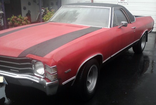Ford El Camino with spray paint repair and black racing stripes painted on it